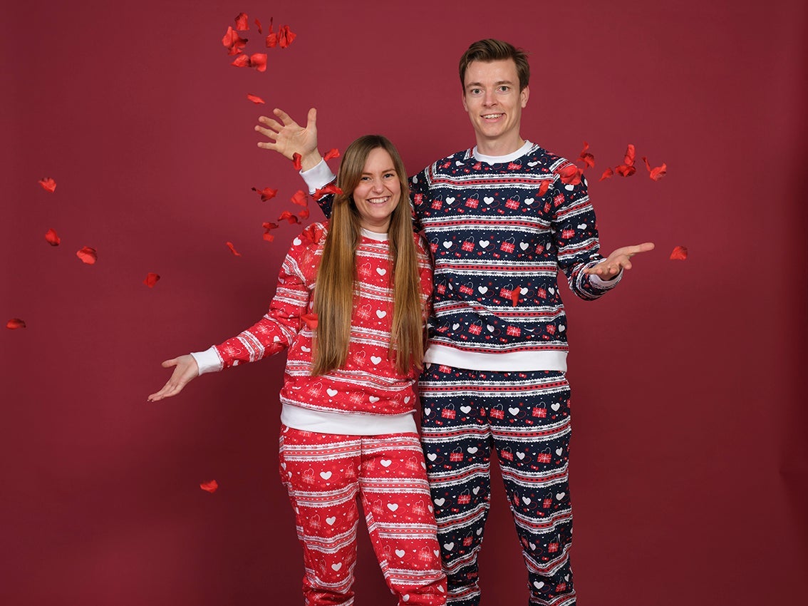 Ett par håller om varandra iförda en valentinsoverall.